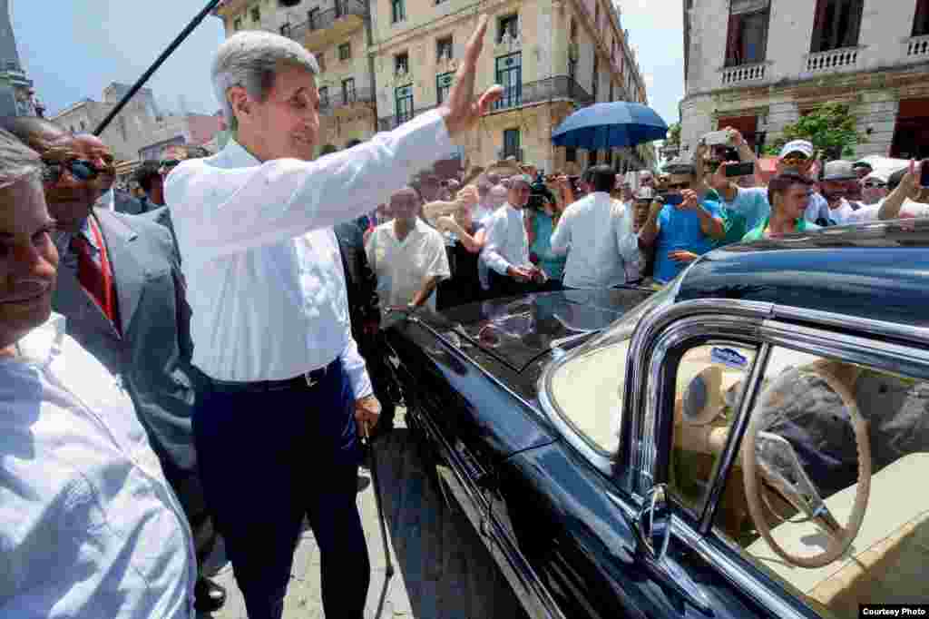 Kerry saluda a los cubanos antes de montarse en un viejo Chevrolet Impala.