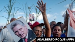 Una mujer sostiene un cartel con la imagen de Miguel Díaz-Canel durante una marcha en La Habana. (Adalberto Roque/AFP)