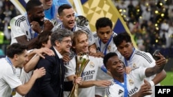 El delantero brasileño #7 del Real Madrid, Vinicius Junior, posa para una foto "selfie" con sus compañeros de equipo después del partido de fútbol final de la Copa Intercontinental de la FIFA 2024