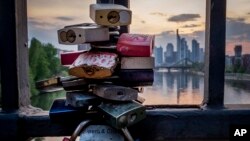 Candados sobre un puente en el río Main, en Frankfurt, con el distrito financiero al fondo. (AP/Michael Probst)