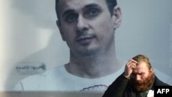 Un hombre se detiene frente a una imagen gigante del cineasta ucraniano Oleg Sentsov en una calle de Kiev. 