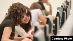 Dos estudiantes universitarias trabajan frente a una computadora. Foto: Univ. Navarra