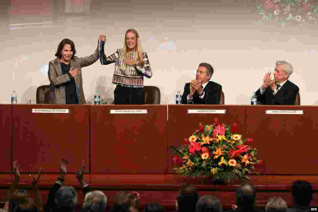 El escritor peruano, Mario Vargas Llosa (d) y el rector de la Universidad de Lima, Óscar Quezada (2-d), aplauden a las esposas de los opositores venezolanos presos Leopoldo López y Antonio Ledezma, Lilian Tintori (2-i) y Mitzy Capriles (i), en seminario i